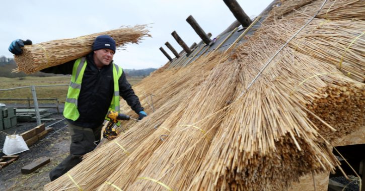 man thatching a roof at Kynren The Storied Lands.